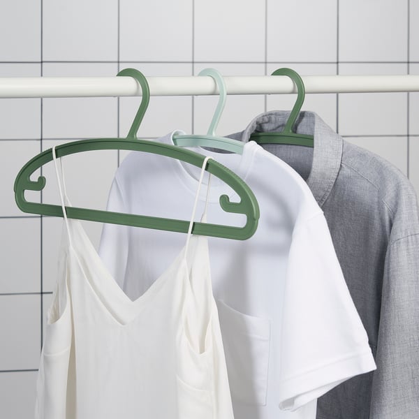 Clothes hangers with anti-slip shoulders in green, holding white and grey tops.
