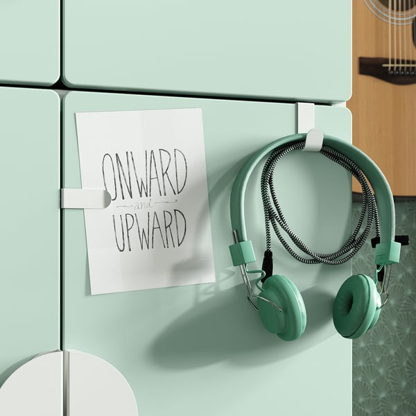 A light blue fridge with a white magnet holding headphones and a note reading onward and upward.
