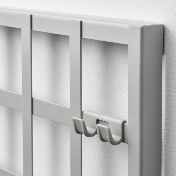 Modern wall-mounted organiser with hooks and compartments. Elegant white design for efficient storage.