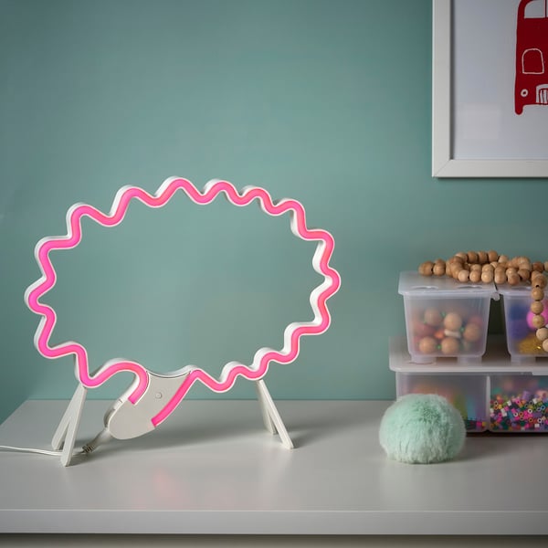 Color-changing led lamp shaped like a speech bubble on desk, next to toys.