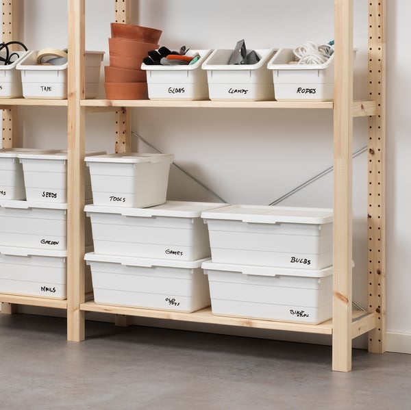 Wooden shelves with labelled storage boxes for organising tools, seeds, and games.