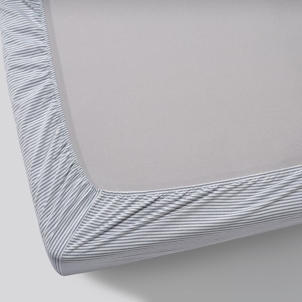 Grey fitted sheet with white stripes, elastic edges, laid on a mattress, showcasing its quality material and design.