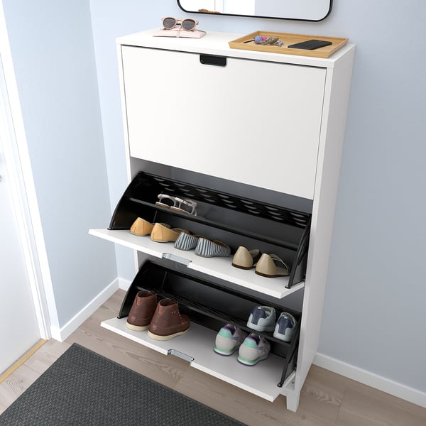 White shoe cabinet with open drawers, storing various footwear; has metal-edged handles and front legs.