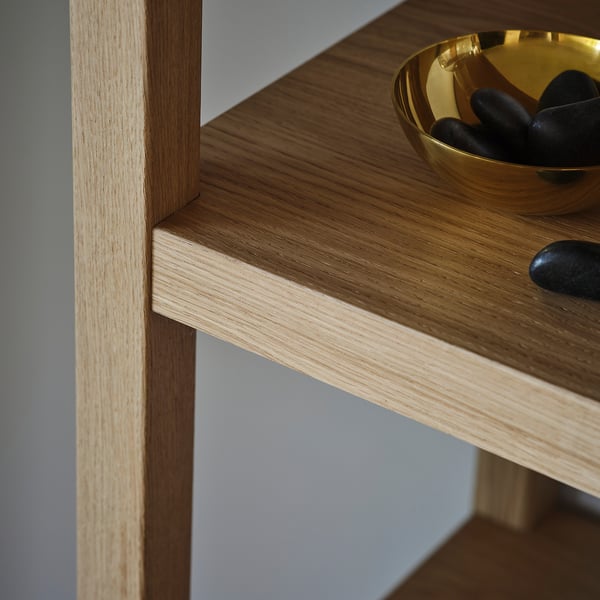 A wooden shelf with clean lines and a smooth finish, displaying a few decorative items. High-quality craftsmanship is evident.
