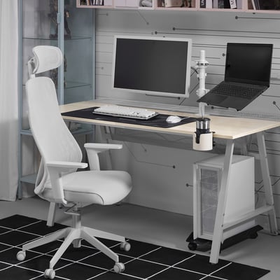 Minimalist home office: wooden desk, ergonomic chair, computer setup, chequered rug.