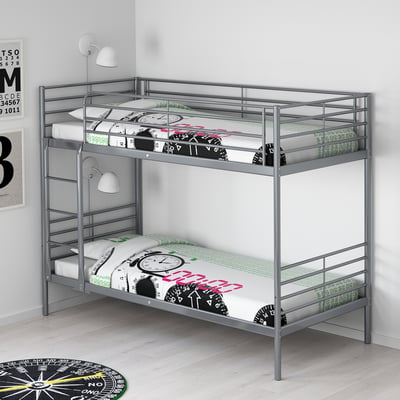 Silver SVÄRTA bunk bed with clocks design, fitting snugly into room corner, smaller than surrounding decor.