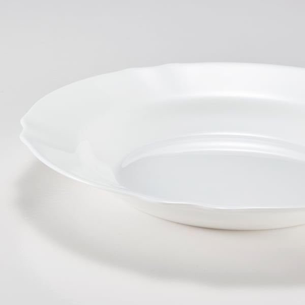 Close-up of elegant, wavy-edged white glass plate, clean and pristine.