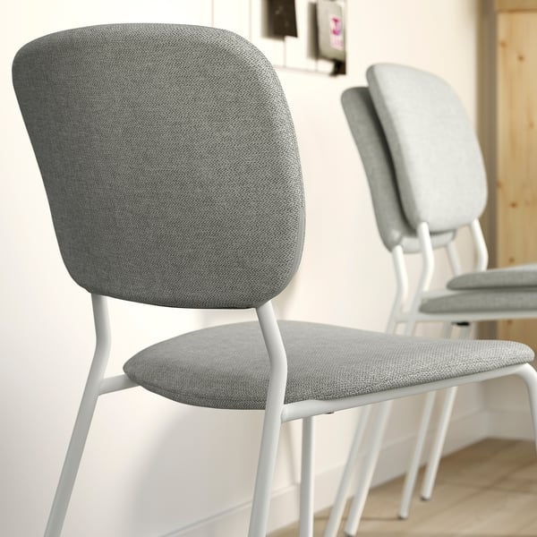 Modern grey fabric dining chairs with white metal legs, stylish & easy to clean.