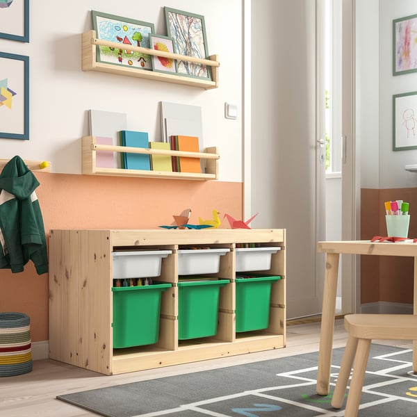 Wooden TROFAST storage for kids, light with green bins. Low, accessible, colourful toys around.
