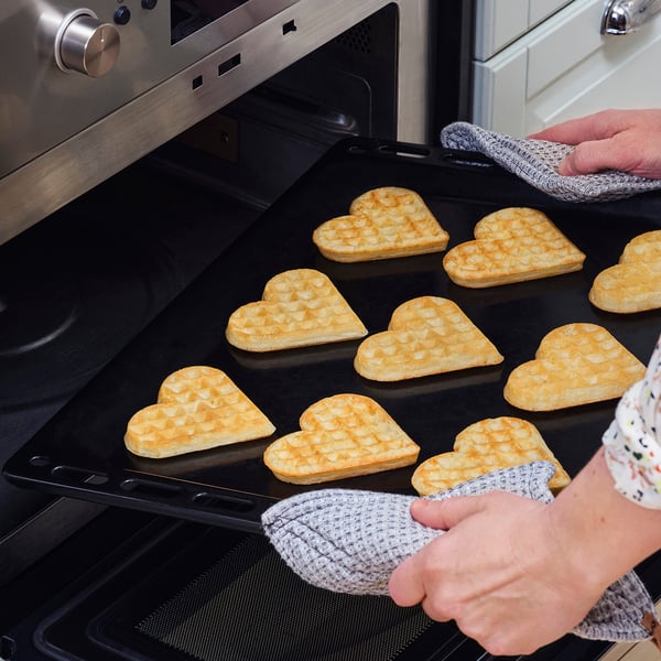 Baking heart-shaped waffles in an oven on a tray.