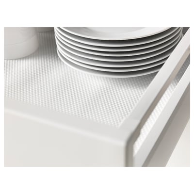 Stack of white plates on a textured drawer mat, reducing noise and preventing scratches.