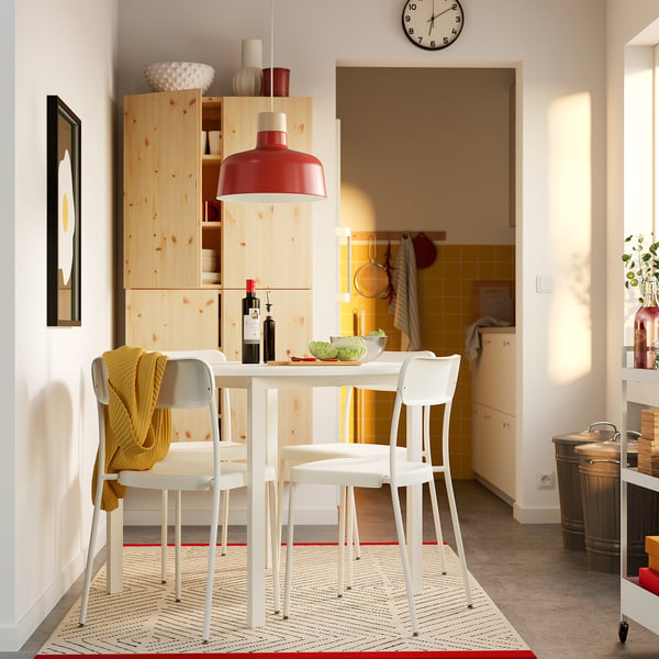 Modern dining set with red lamp and shelves.