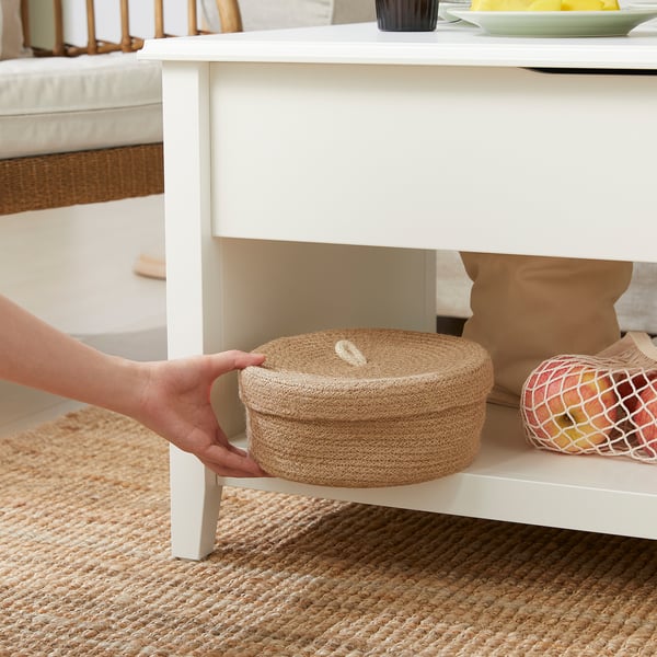 Hand adjusting two-tiered coffee table with storage and adjustable height.