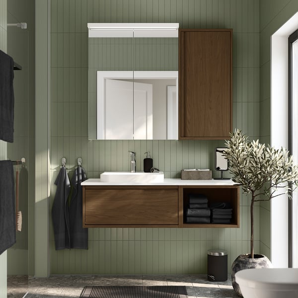 Brown oak bathroom vanity with marble counter, open shelving.