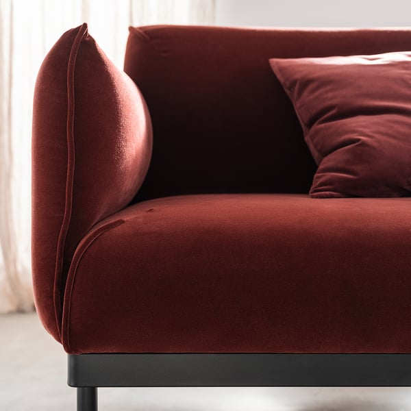 Modern red velvet sofa, plush cushions, sleek metal legs.