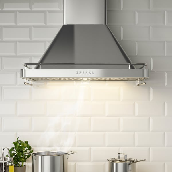 Modern kitchen extractor hood with led light, control panel, and spice rack, mounted against white tiled wall.