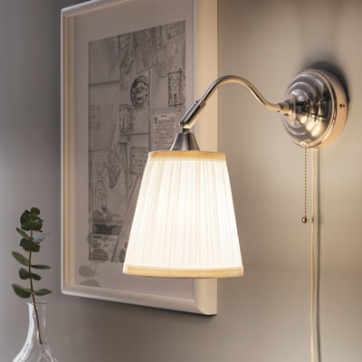Wall-mounted lamp with adjustable neck casting soft light. White shade and pull switch.