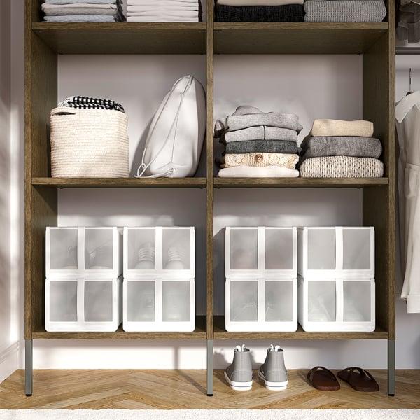 Wooden closet shelves with clear storage boxes, folded clothes, and shoes.