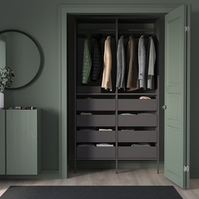 Dark grey AURDAL closet with shelves, drawers, and clothes; green walls.