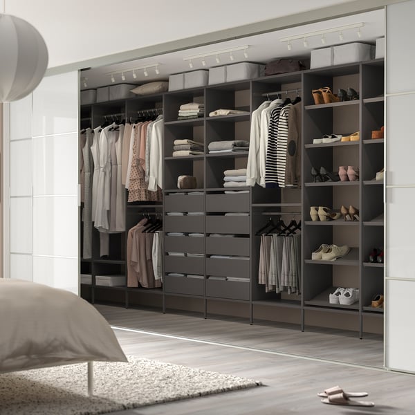 Modern walk-in closet with AURDAL system. Grey shelves, hanging rods, and drawers for efficient storage. Well-lit, sleek design.