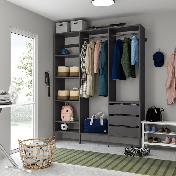 Modern grey closet system with shelves, drawers, and hanging space, featuring a striped rug and basket in a bright room.