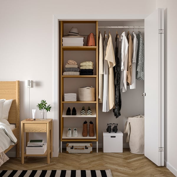 Walk-in closet with AURDAL storage system. Wooden shelves and hangers, neatly arranged clothes, shoes, and accessories.