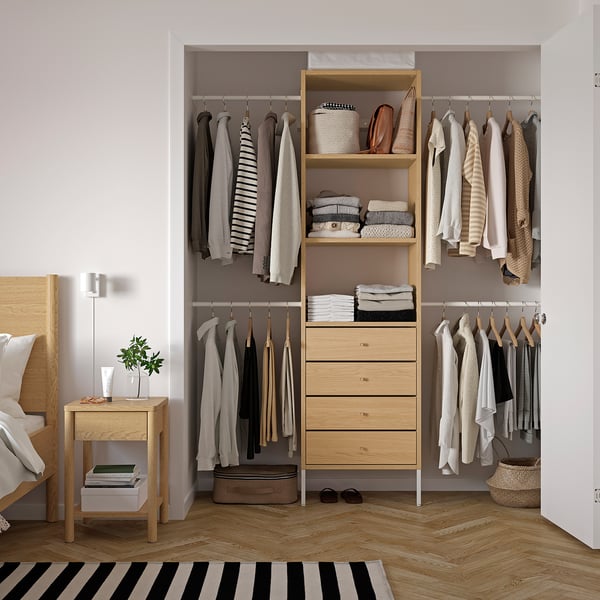 Organised closet with AURDAL storage, clothes, lamp, plant.
