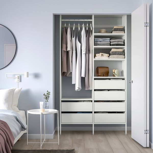 White AURDAL closet with clothes & drawers, next to bed & mirror.