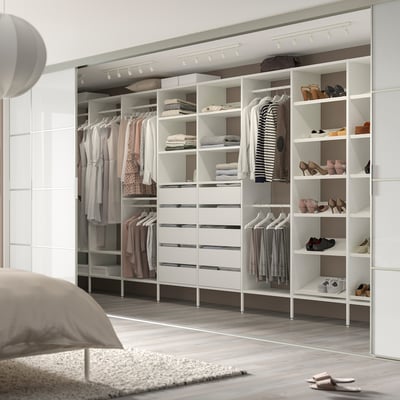 Organised walk-in closet with AURDAL white storage, track lighting, and rug.