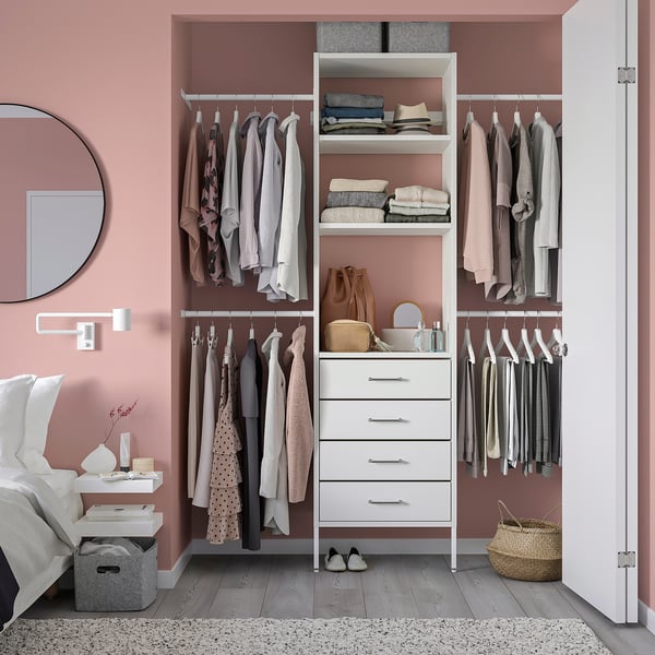 Organised closet with AURDAL system, white shelves, pink walls, mirror.