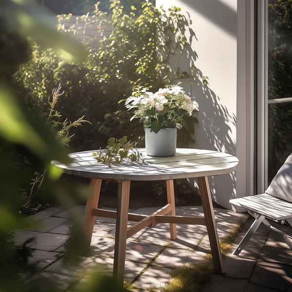 Small outdoor table with wooden legs holds potted plants in round metal vase, ideal for displaying greenery on a patio.