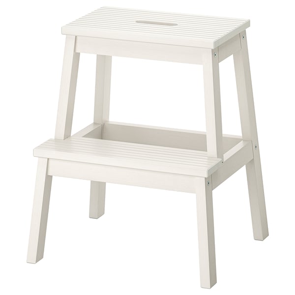 A white BEKVÄM step stool with a rectangular top and four angled legs, made from solid rubberwood.