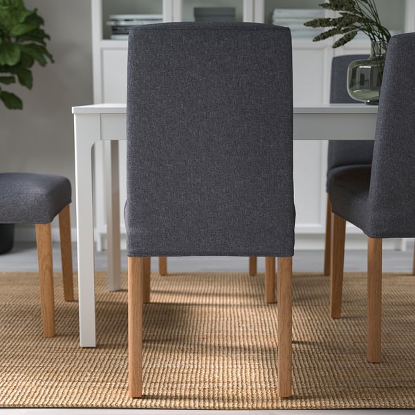 Modern dining set with grey upholstered chairs. Chairs have wooden legs and removable covers.