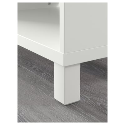 Close-up of a white BESTÅ unit leg on wooden floor, showcasing high-quality design and sturdy construction.