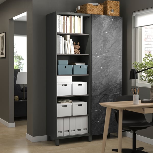 Modern home office featuring a BESTÅ storage unit in black with blue and white boxes, holding books and decor on open shelves.