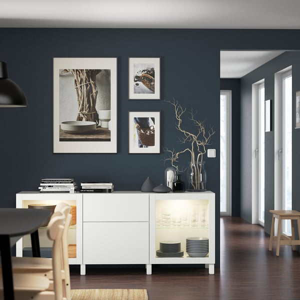 Modern dining room with BESTÅ sideboard, dark walls.