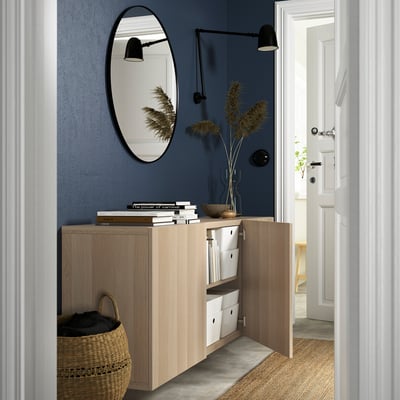 Modern, wall-mounted wooden cabinet with open doors revealing storage boxes, showcasing an airy and organised look.