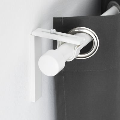 White adjustable curtain rod bracket mounted on dark grey wall, holding silver curtain rod, demonstrating versatility in curtain placement.