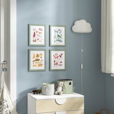 Four animal prints hang above a white dresser with blue wall. Right, a cloud lamp; dresser holds train, plant, bunny, and two green containers.
