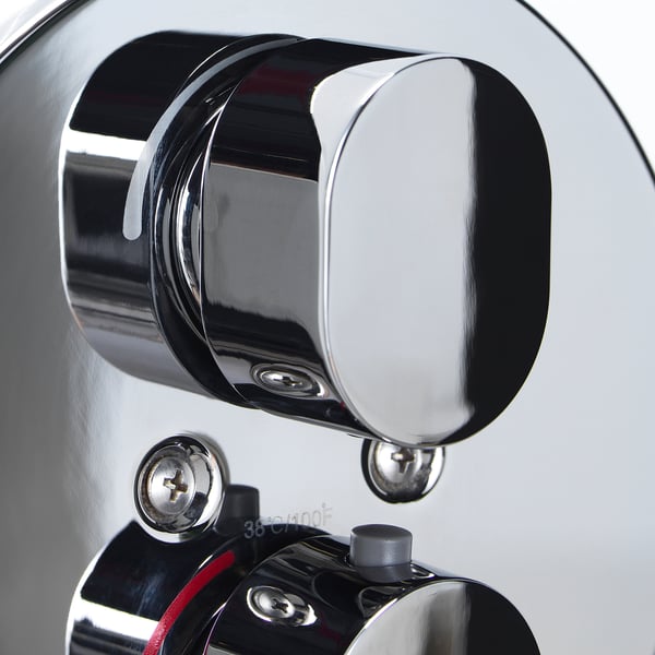 Close-up of chrome shower mixer handle with temperature and flow controls, featuring safety stop and full/mesh spray options.