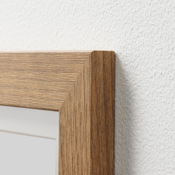 Closeup of wooden picture frame edge. Clear grain detail, solid design.