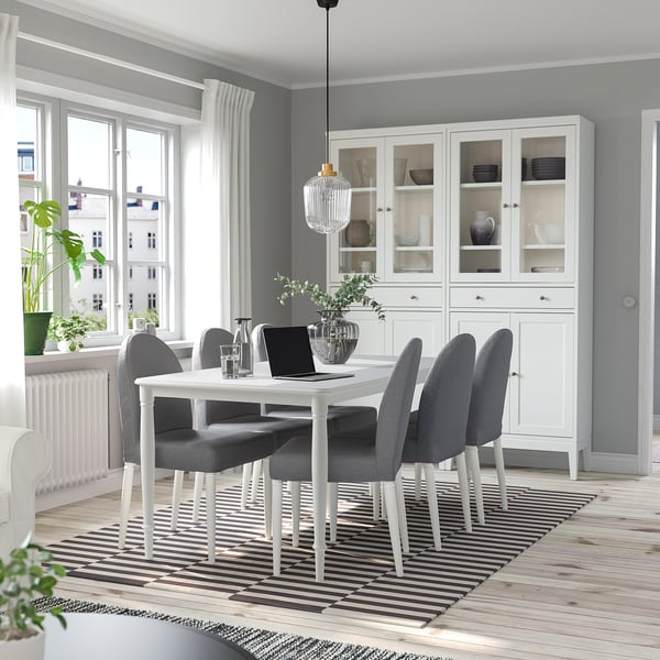 Modern dining set with DANDERYD table and grey chairs, white cabinet, stripe rug.