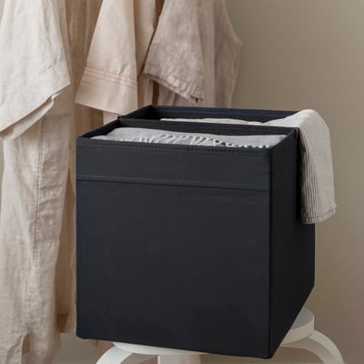 Black storage box with removable divider, organising items in two compartments.