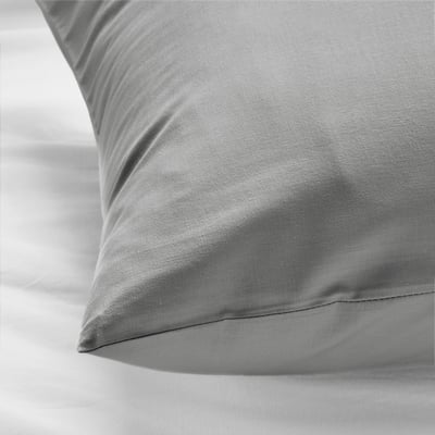 Soft, smooth, grey cotton pillowcase on bright, clean sheet.