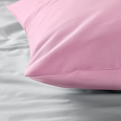 Soft pink pillowcase on bed, appearing smooth and well-made. Appears comfortable and high-quality.