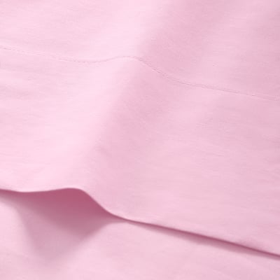 Smooth, light pink fabric in close-up, showcasing soft texture and neat stitching.