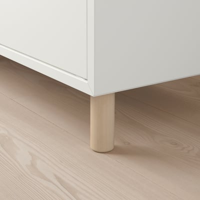 White furniture with light wooden legs on a wooden floor. Sturdy design, slightly raised off the ground.