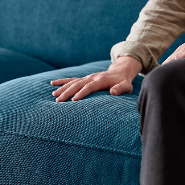 Hand on teal ESSEBODA sofa, soft chenille fabric, deep seats, high backrest.
