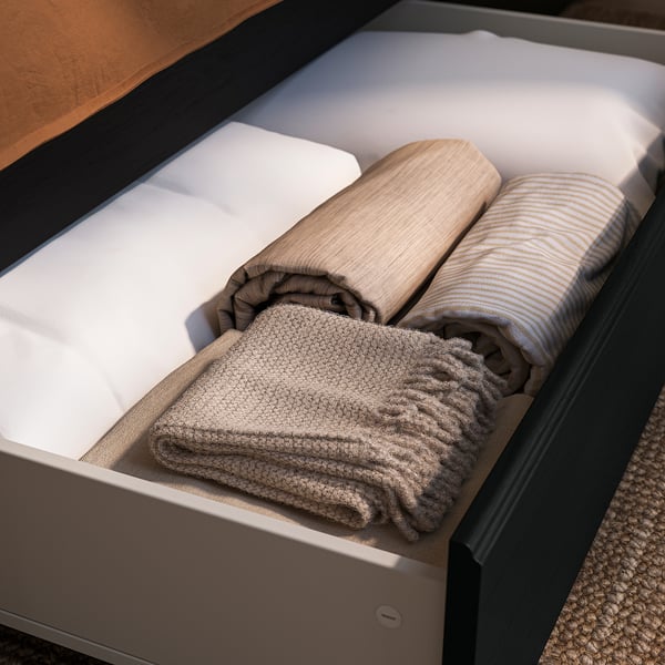 Open drawer with folded blankets and towels neatly stacked.