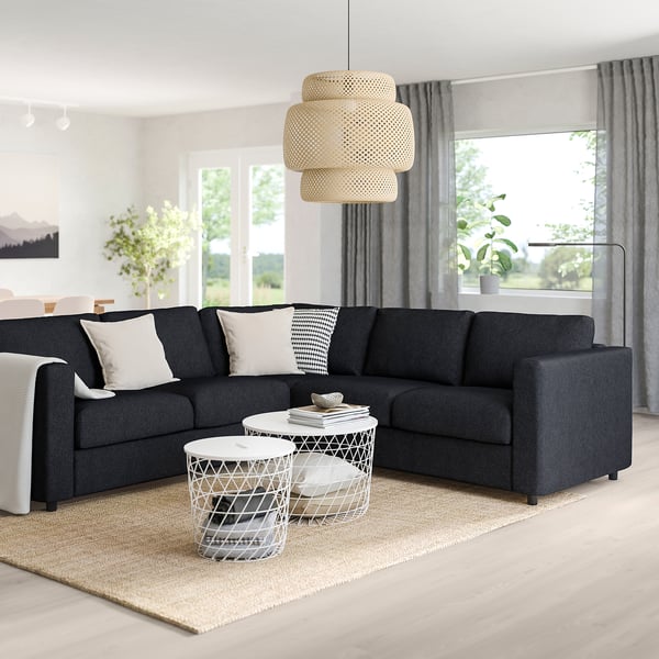 Modern living room with dark grey FINNALA sectional sofa, white cushions, and minimalist decor.